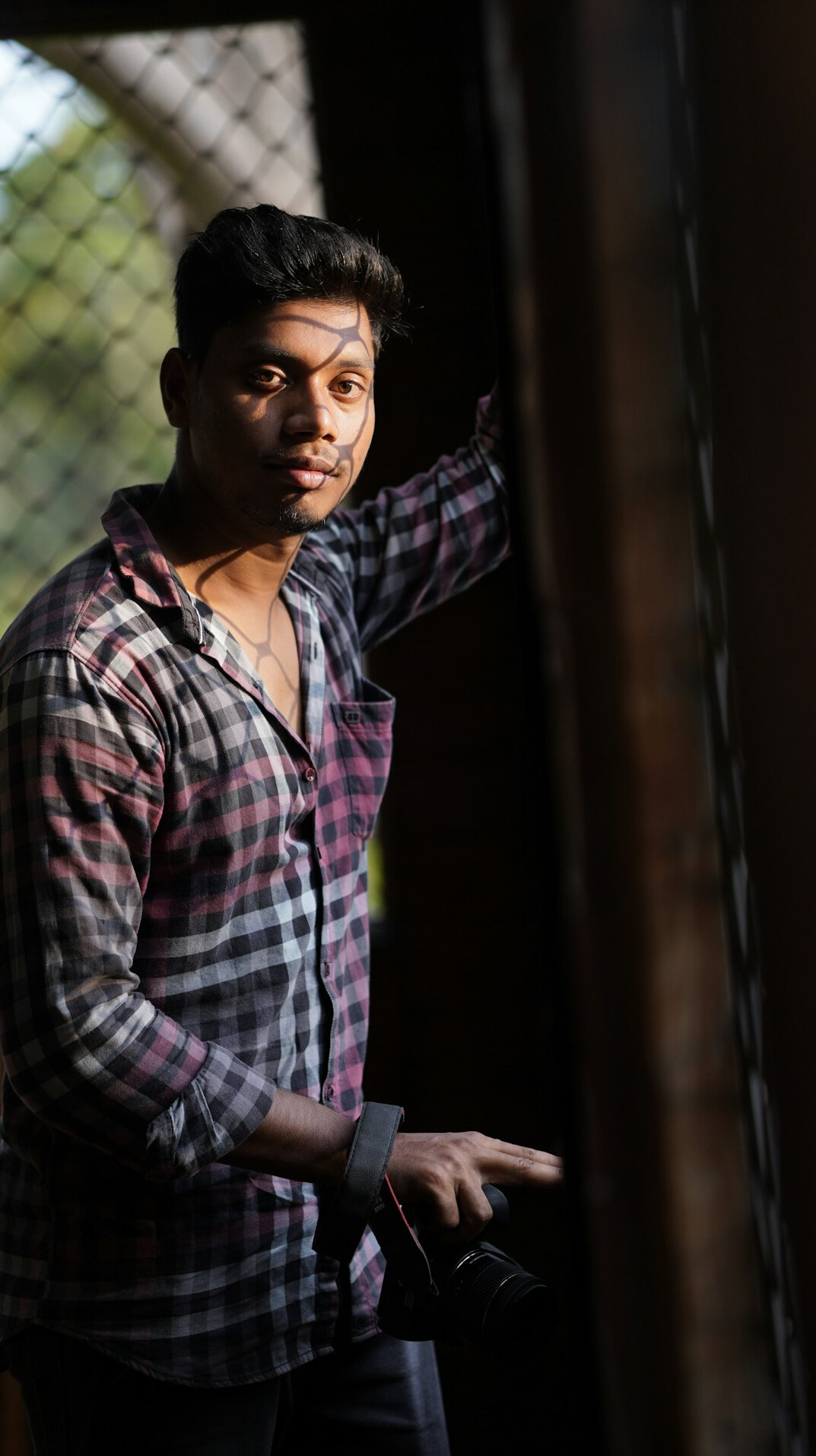 Portrait of a South Asian Canadian male photographer holding a camera